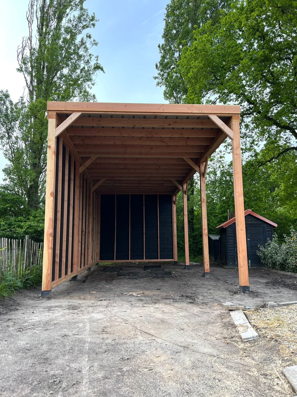 Open voorzijde van een houten schuilstal met dichte achterwand